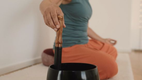 Gabriele schlägt die Klangschale im Yoga-Studio