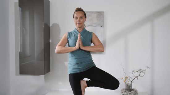 Gabriele liegt entspannt in Rückenlage auf einer Yogamatte im Yoga-Studio