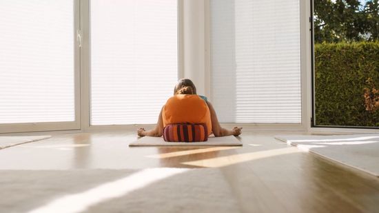 Gabriele liegt entspannt in Rückenlage auf einer Yogamatte im Yoga-Studio
